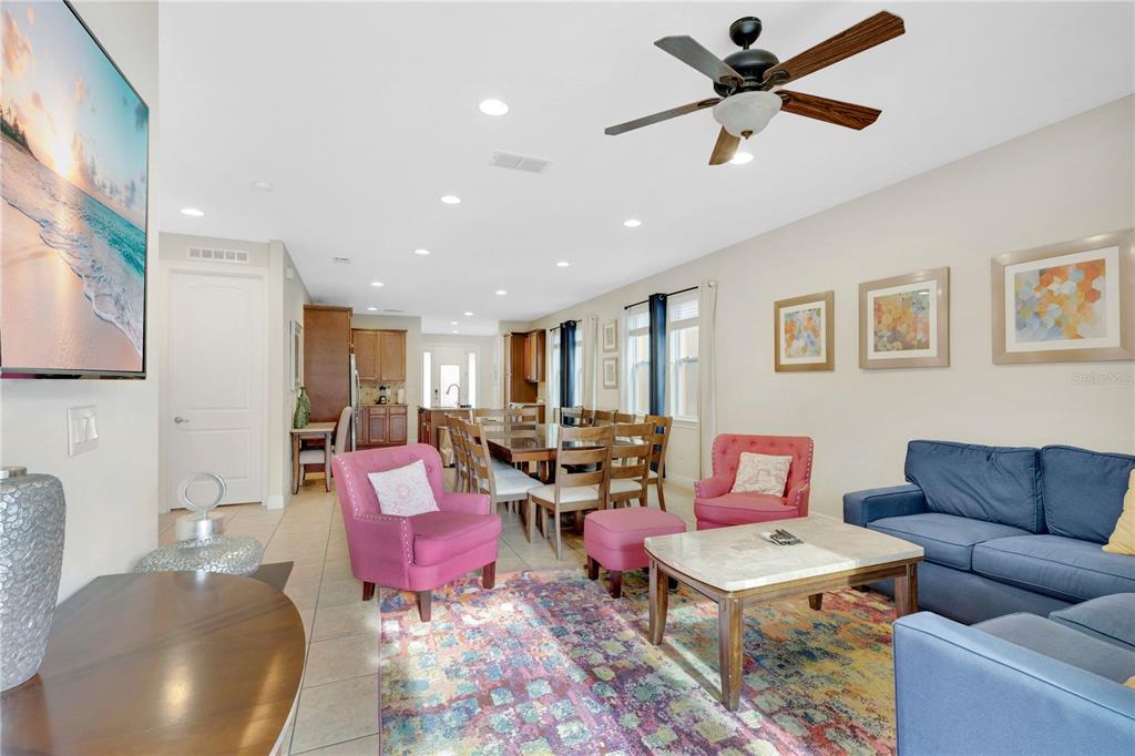 A living and dining area features tile floors, a ceiling fan, and colorful furniture — 410 NOVI PATH, KISSIMMEE, FL