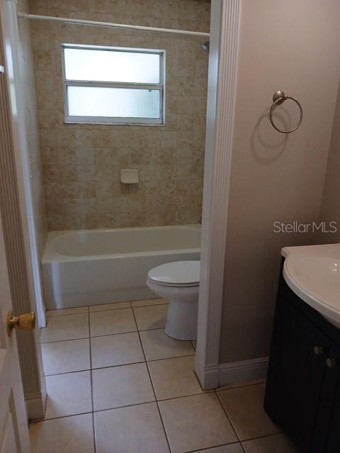 A bathroom features a tiled shower-tub combination, a white toilet, and a dark vanity — 3808 CYPRESS AVENUE, SANFORD, FL