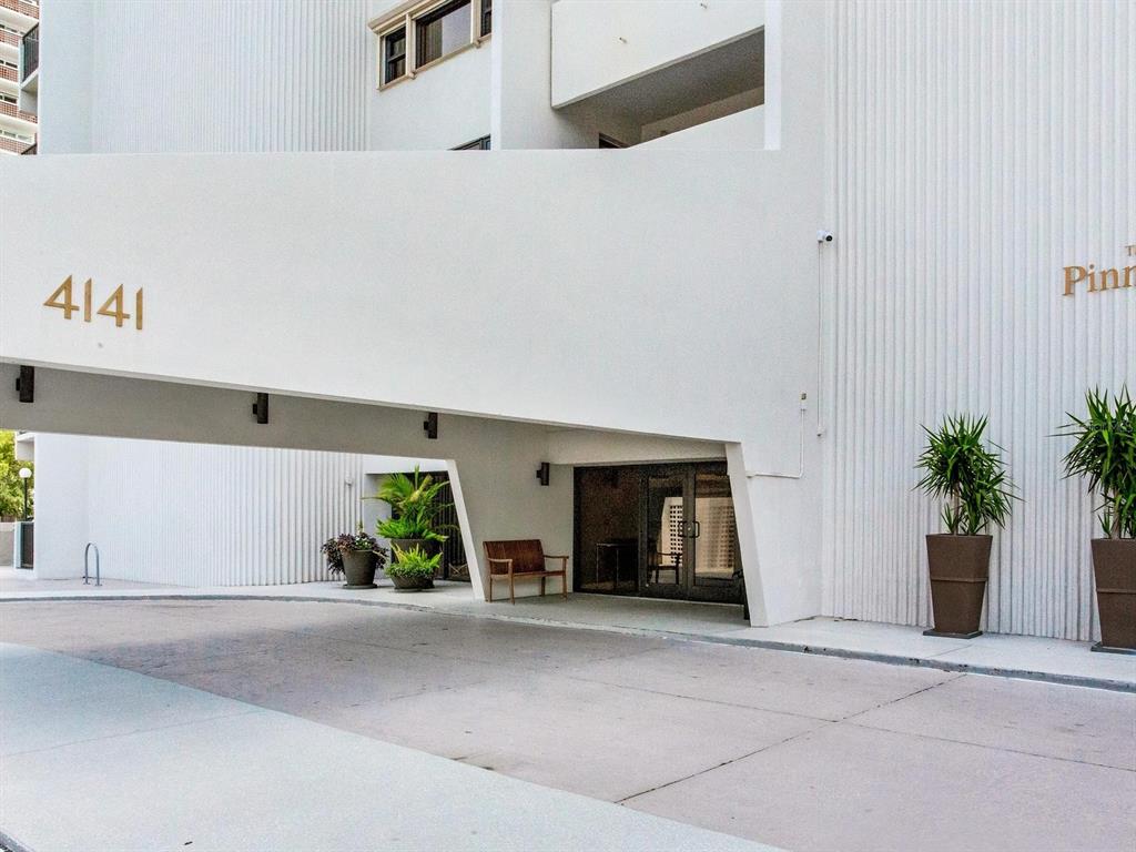 A white building exterior features a covered entrance with a bench and potted plants — 4141 BAYSHORE BOULEVARD UNIT 505, TAMPA, FL