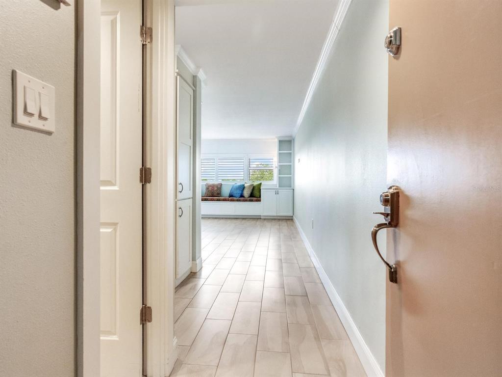 A hallway with light-colored tile flooring leads toward a room with a window seat — 4141 BAYSHORE BOULEVARD UNIT 505, TAMPA, FL