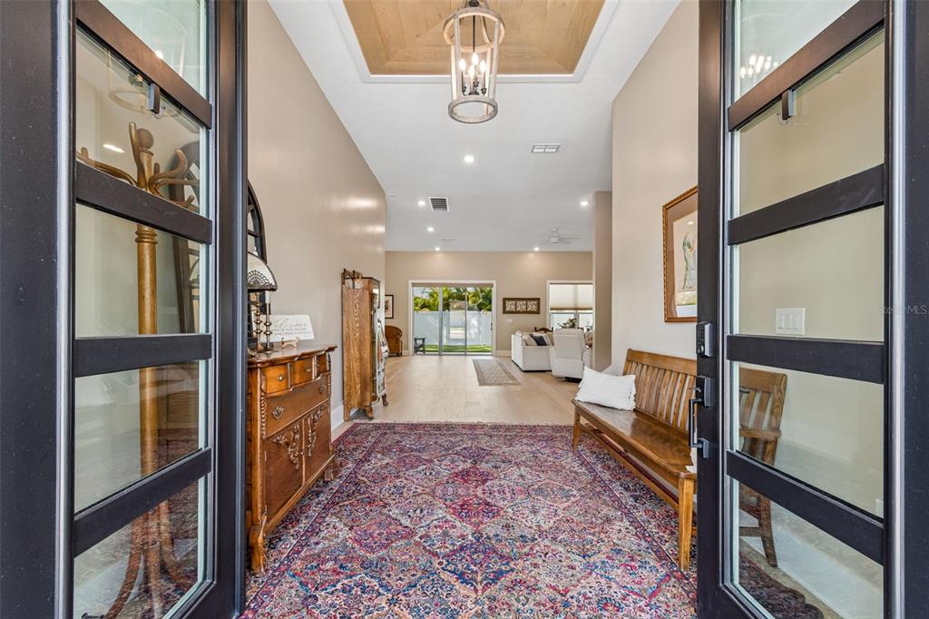 An entryway features a patterned rug, a wooden bench, a chest, and a tray ceiling — 4022 W BAY TO BAY BOULEVARD, TAMPA, FL