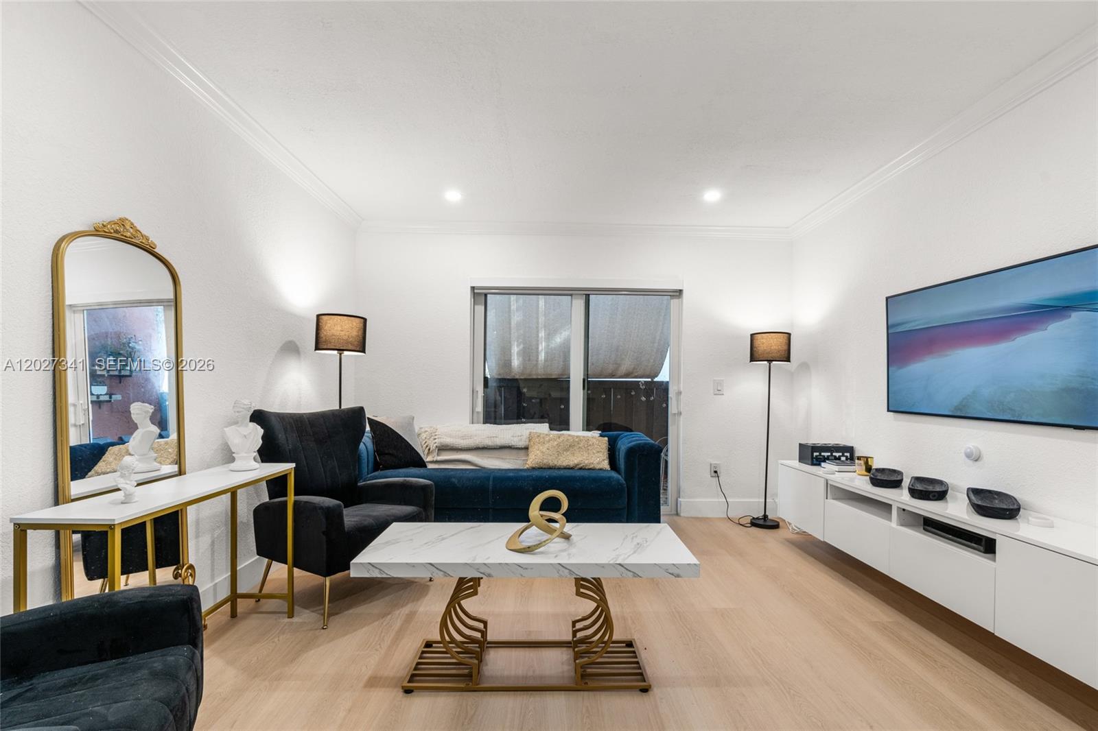 A living room features a blue sofa, a marble coffee table, and a wall-mounted television — 10780 N Kendall Dr # E7, Miami FL 33176, MIAMI, FL