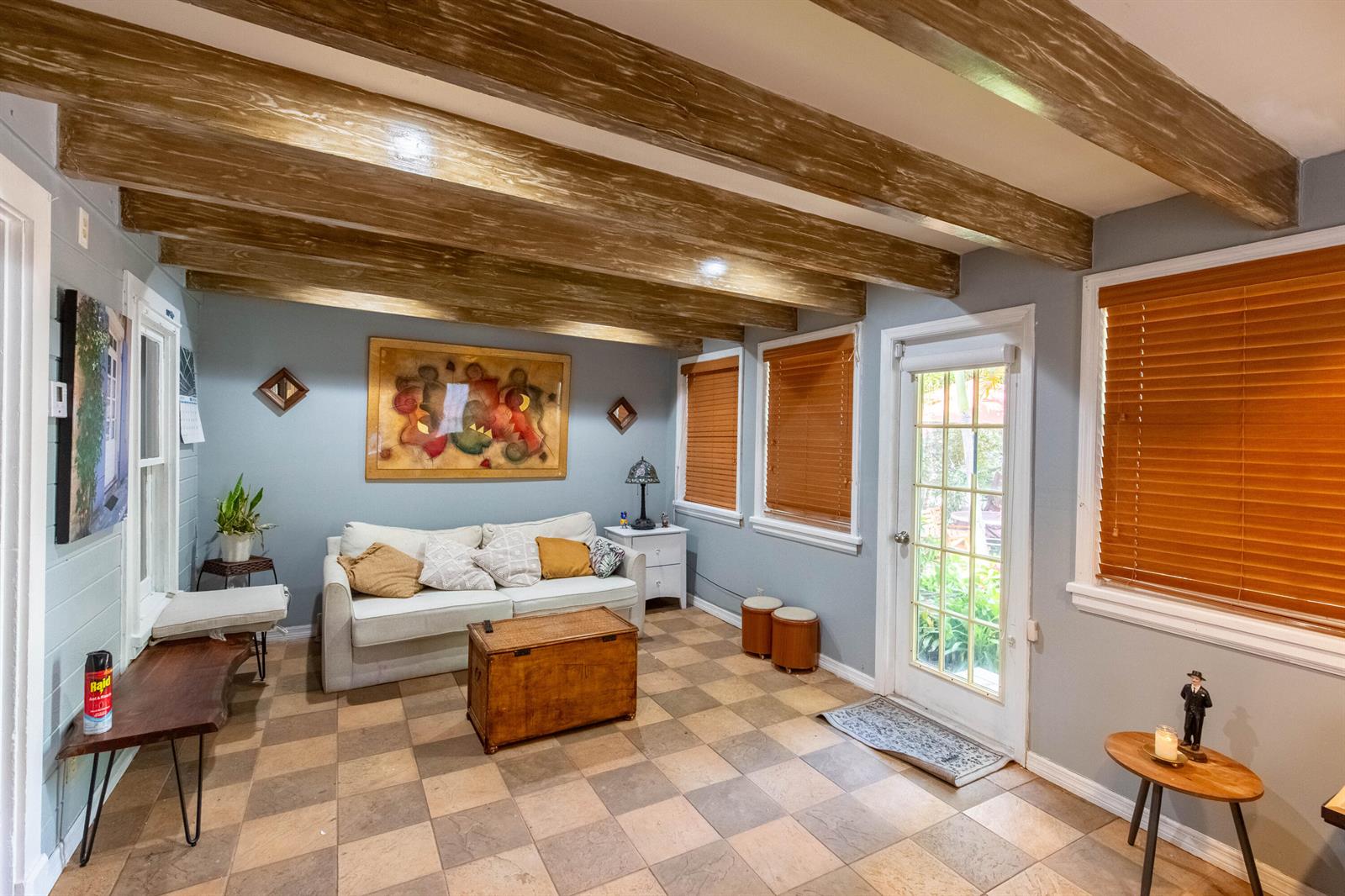 A living room features exposed wooden ceiling beams, tiled floors, a sofa, and a glass door — 1016 N E Street, FL 33460, FL
