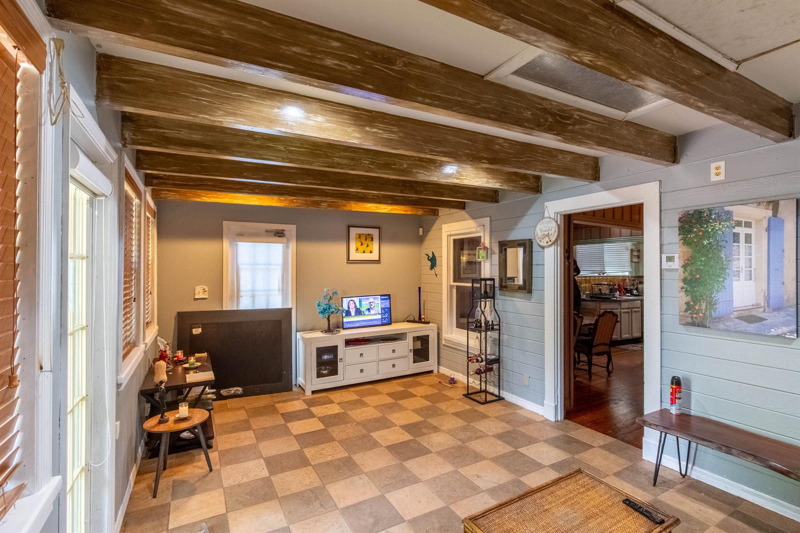 A living room features exposed wooden ceiling beams, checkered tile flooring, and light blue walls — 1016 N E Street, FL 33460, FL