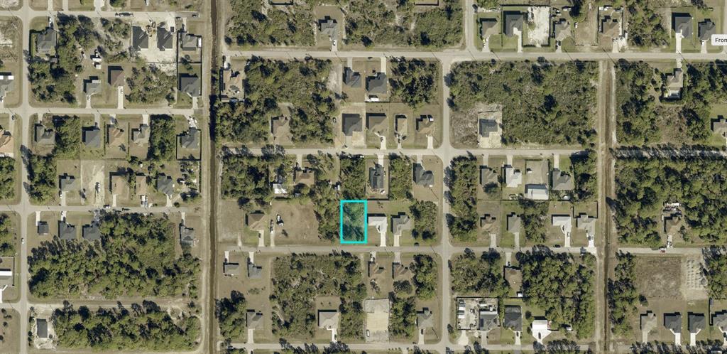 An aerial view shows a vacant rectangular residential lot highlighted in blue within a neighborhood — 3006 40TH STREET W, LEHIGH ACRES, FL