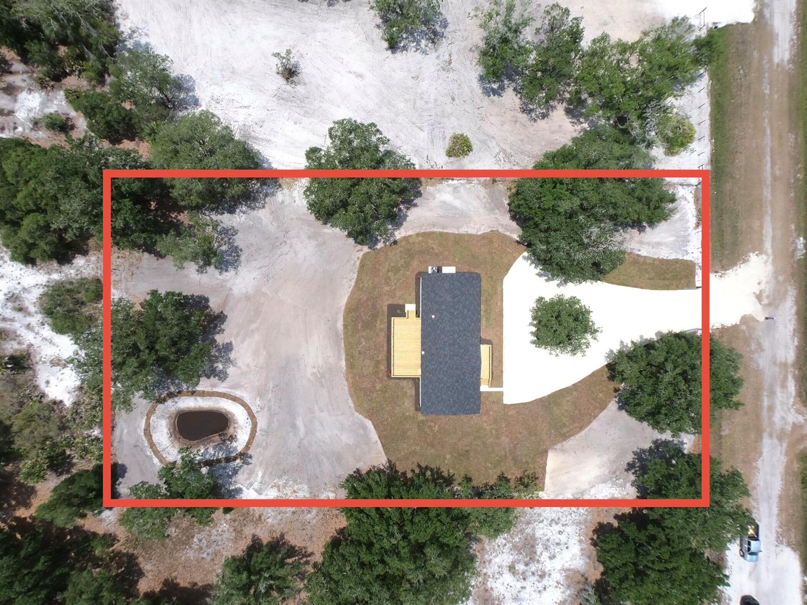 A single-story manufactured home features gray siding, black shutters, and a wooden front deck — 18574 NW 284th Street, Okeechobee FL 34972, OKEECHOBEE, FL