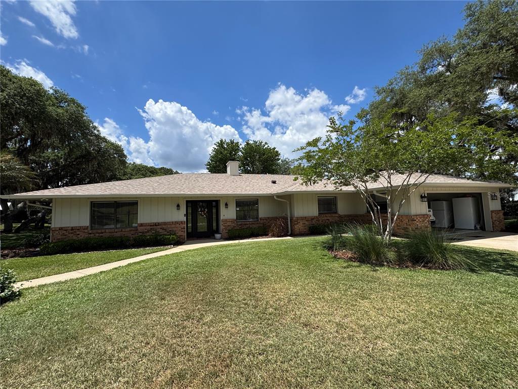 A single-story house with a brick and vertical siding exterior, a garage, and a lawn — 334 W F STREET FL, FROSTPROOF, FL