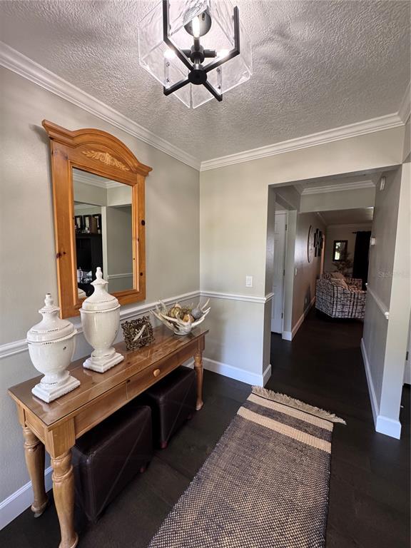 An entryway features a wooden console table, a mirror, and a runner on dark flooring — 334 W F STREET FL, FROSTPROOF, FL