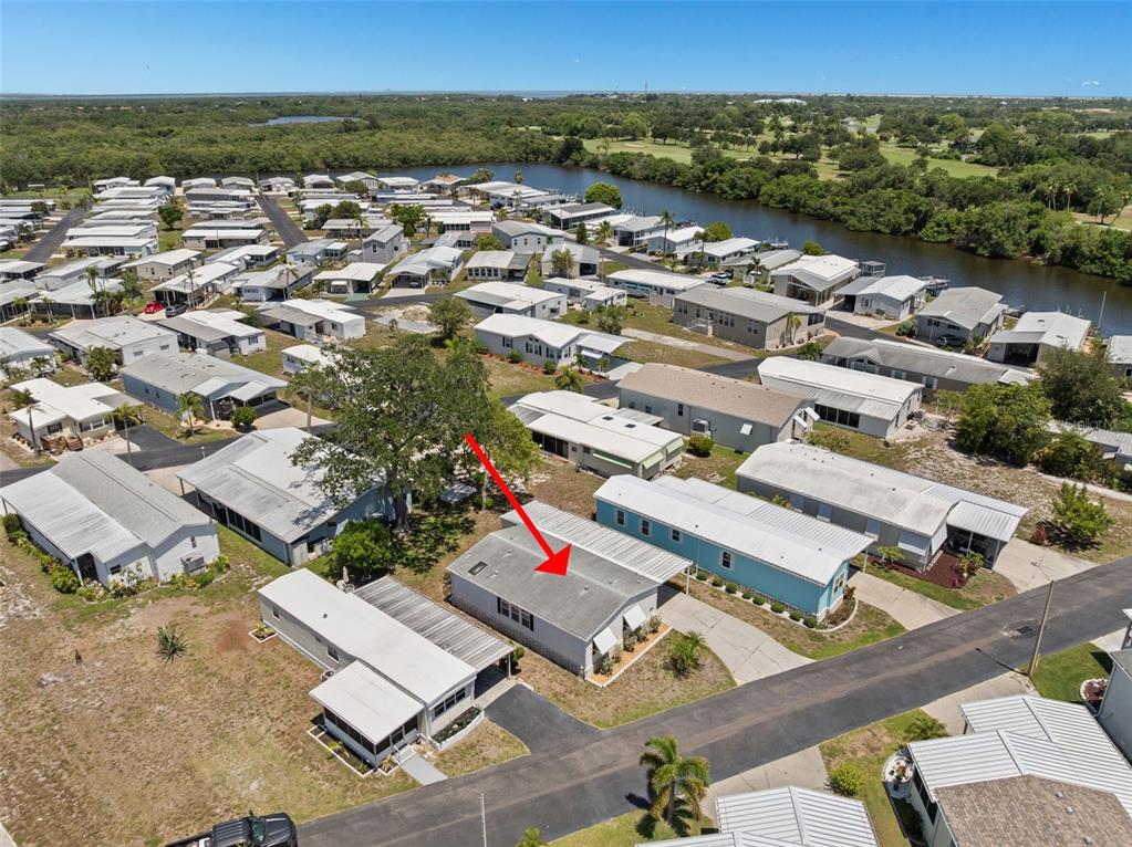 An aerial view shows a manufactured home with a red arrow pointing to its roof — 7107 MOUNT ESSEX DRIVE NE UNIT 520, ST PETERSBURG, FL