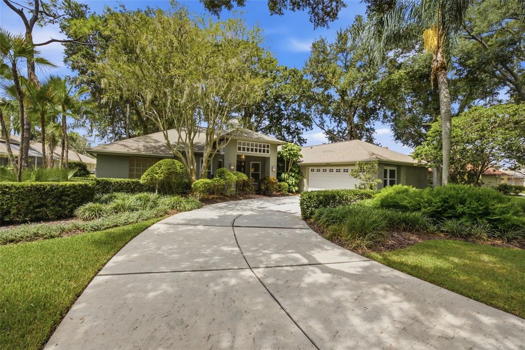 A concrete driveway leads to the front entrance and garage of a single-story suburban home — 16416 WINDSOR PARK DRIVE, LUTZ, FL