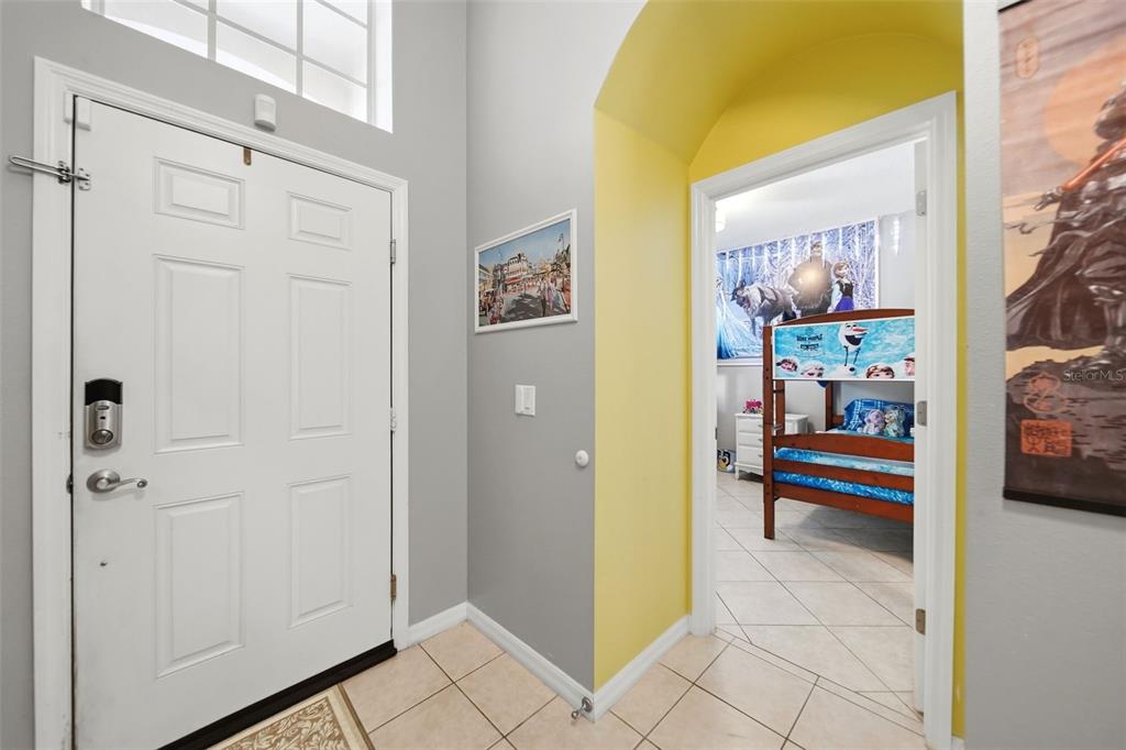 An entryway with a white front door leads to a bedroom featuring a bunk bed — 429 ORISTA DRIVE, DAVENPORT, FL