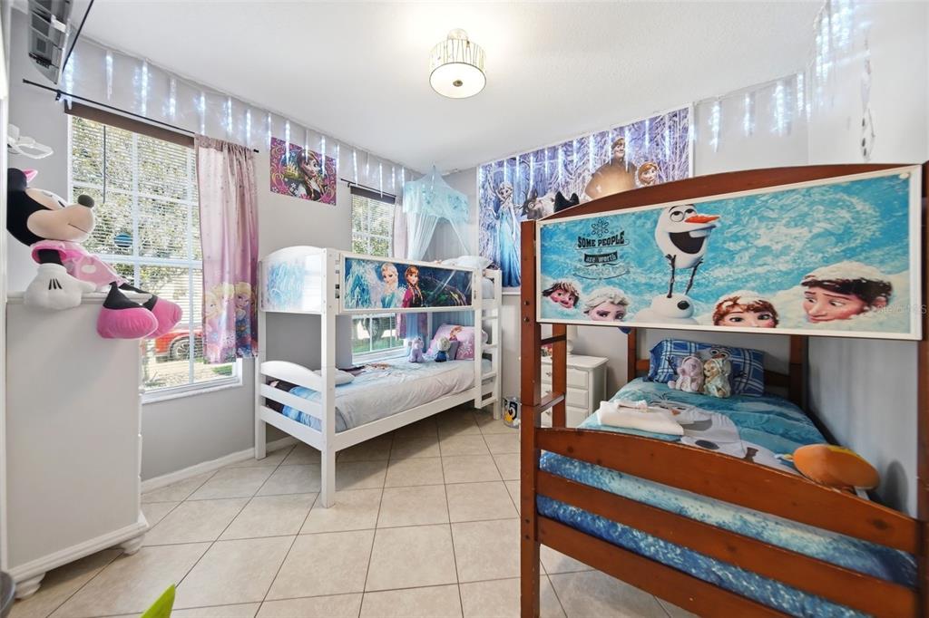 A bedroom featuring two bunk beds decorated with Frozen-themed bedding and wall posters — 429 ORISTA DRIVE, DAVENPORT, FL