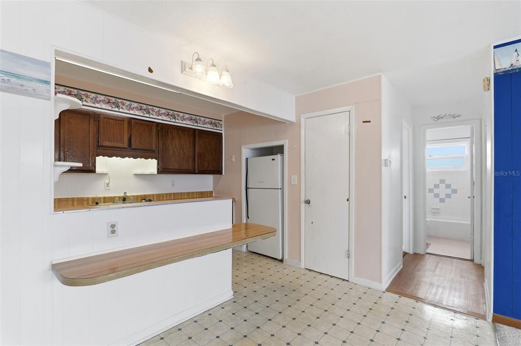 A kitchen with wood cabinets, a breakfast bar, and a white refrigerator — 302 LINCOLN AVENUE UNIT 12, CAPE CANAVERAL, FL