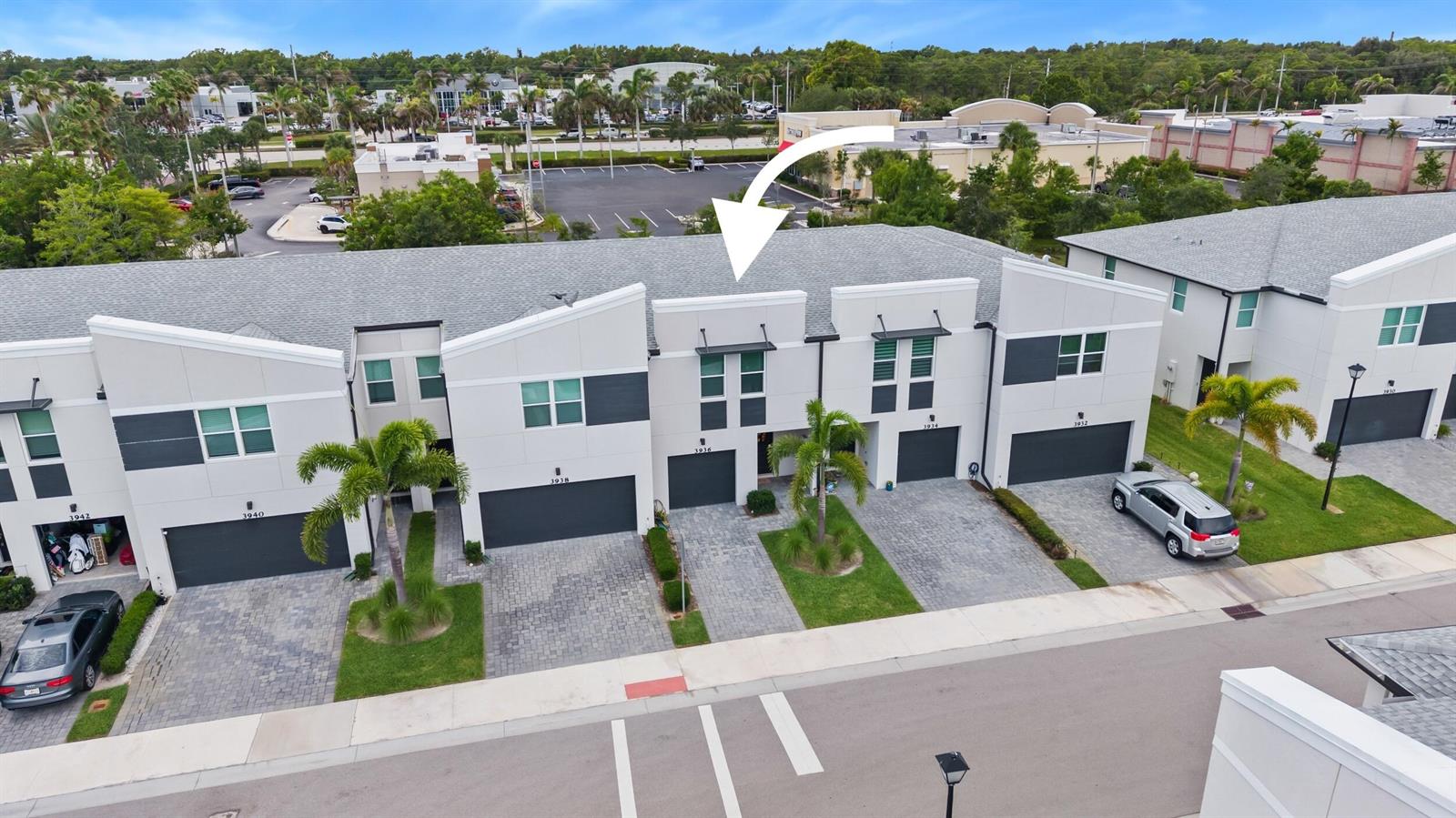 An aerial view shows a row of modern townhomes with gray roofs and white facades — 3936 SE Caladium Court # 3936, Stuart FL 34997, STUART, FL