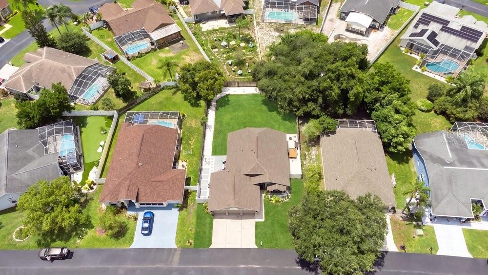 An aerial view shows a suburban neighborhood with several single-family homes featuring pools and lawns — 10551 MAGRATH LANE, NEW PORT RICHEY, FL