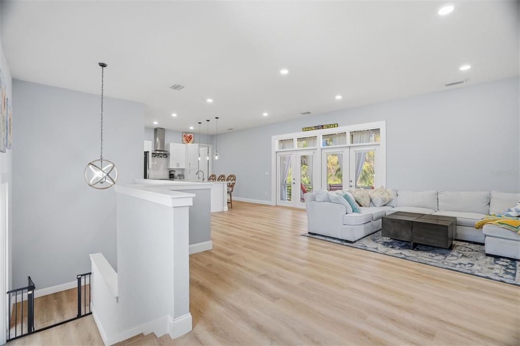 An open-concept living room and kitchen area features light wood flooring and white walls — 4817 LIMESTONE DRIVE, PORT RICHEY, FL