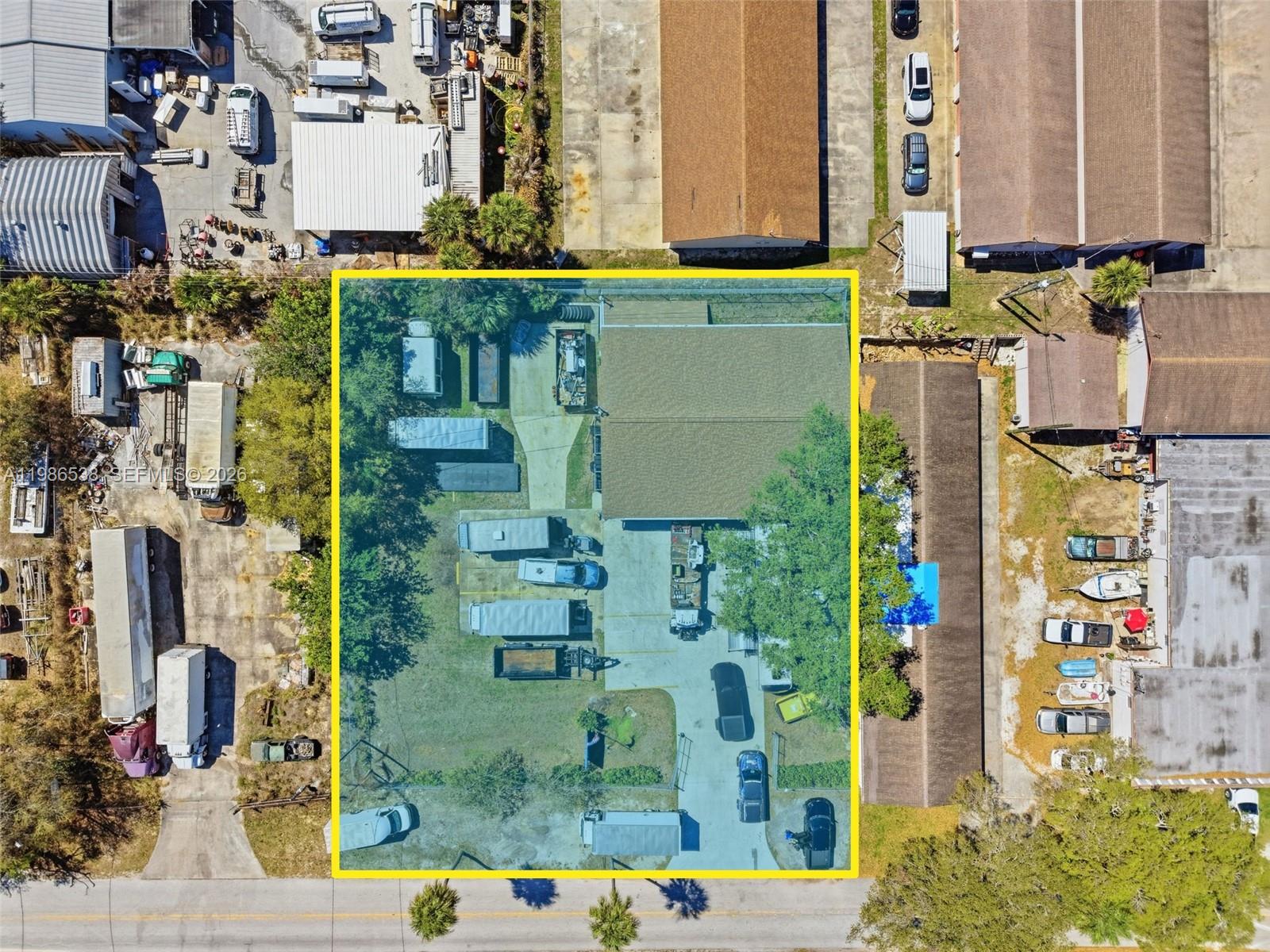 An aerial view shows a fenced industrial lot with a building, trailers, and parked vehicles — 645 Old Dixie Hwy, Sebastian FL 32958, SEBASTIAN, FL