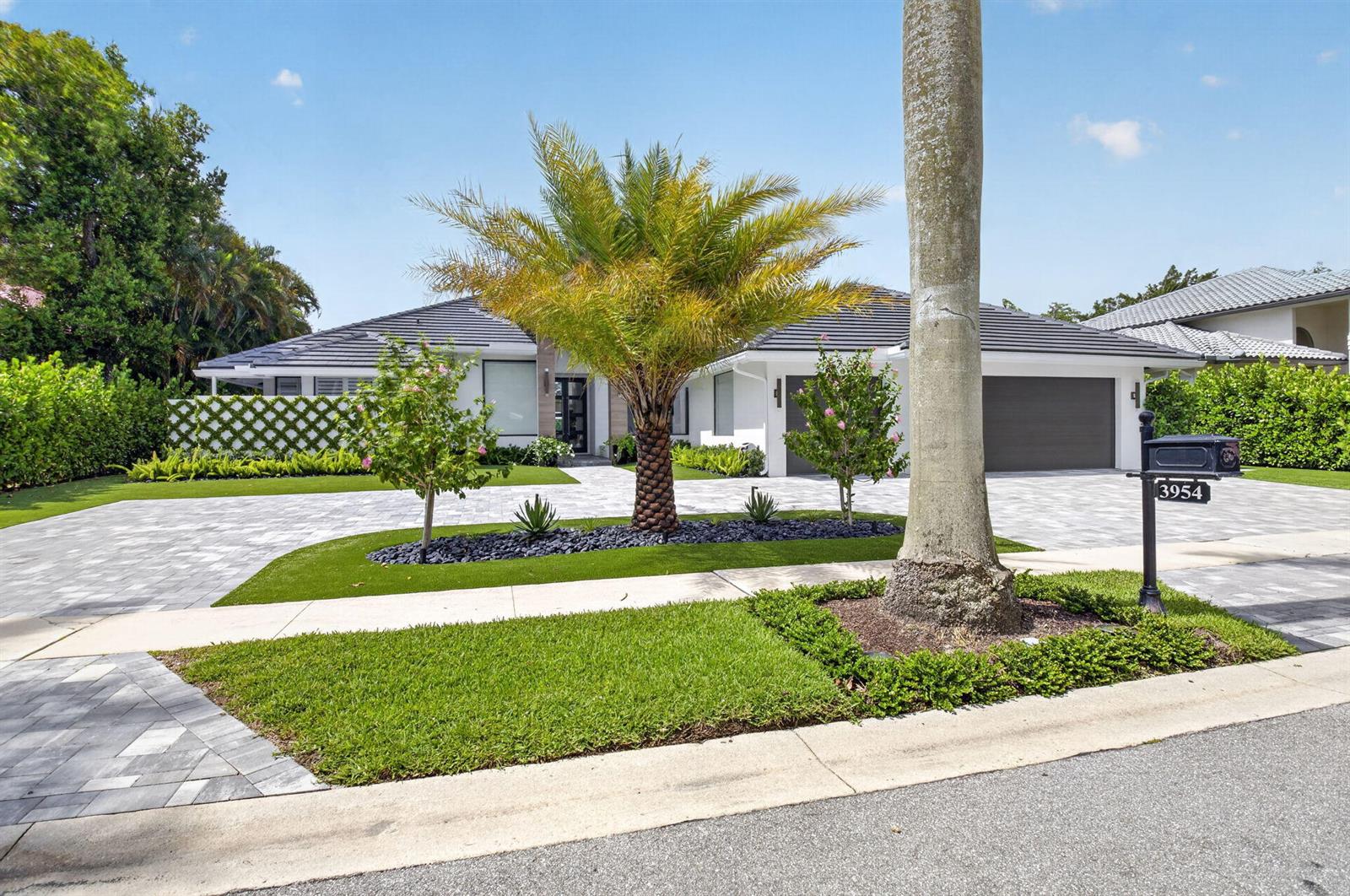 A single-story house with a paved driveway, a palm tree, and a dark garage door — 3954 NW 52nd Street, Boca Raton FL 33496, BOCA RATON, FL