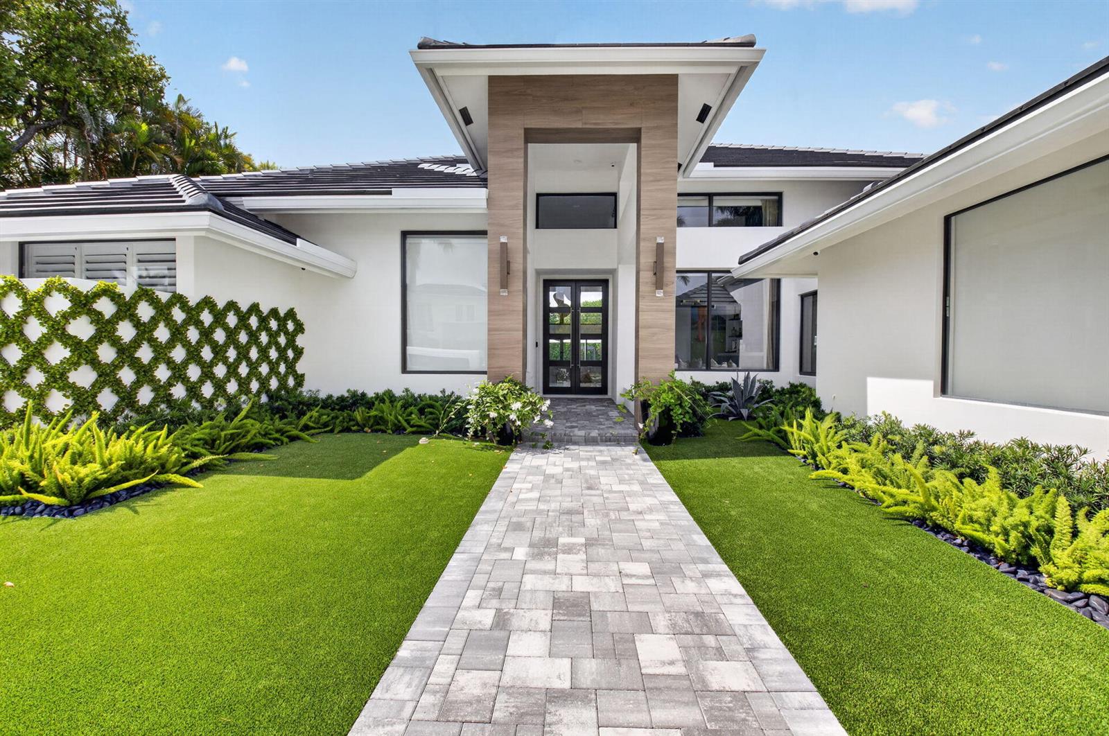 A modern white house with a stone-accented entryway, paved walkway, and manicured green lawn — 3954 NW 52nd Street, Boca Raton FL 33496, BOCA RATON, FL