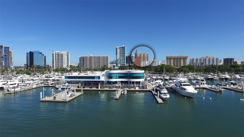 An aerial view shows a marina with many boats in front of a city skyline — 1350 MAIN STREET UNIT 903, SARASOTA, FL
