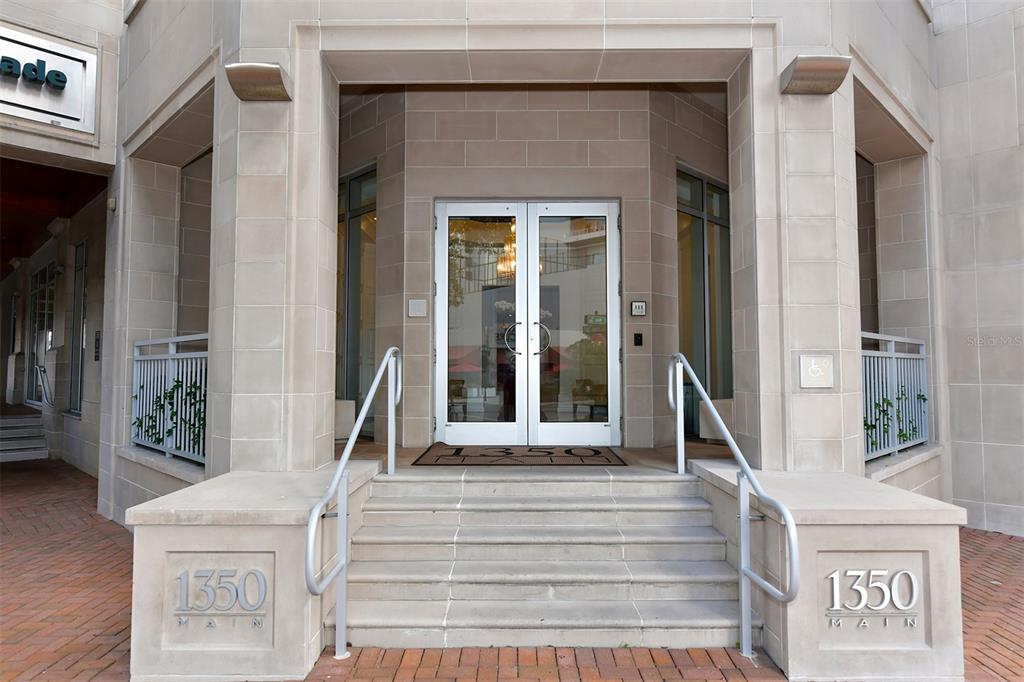 The exterior entrance features stone steps, metal railings, and double glass doors with the number 1350 — 1350 MAIN STREET UNIT 903, SARASOTA, FL
