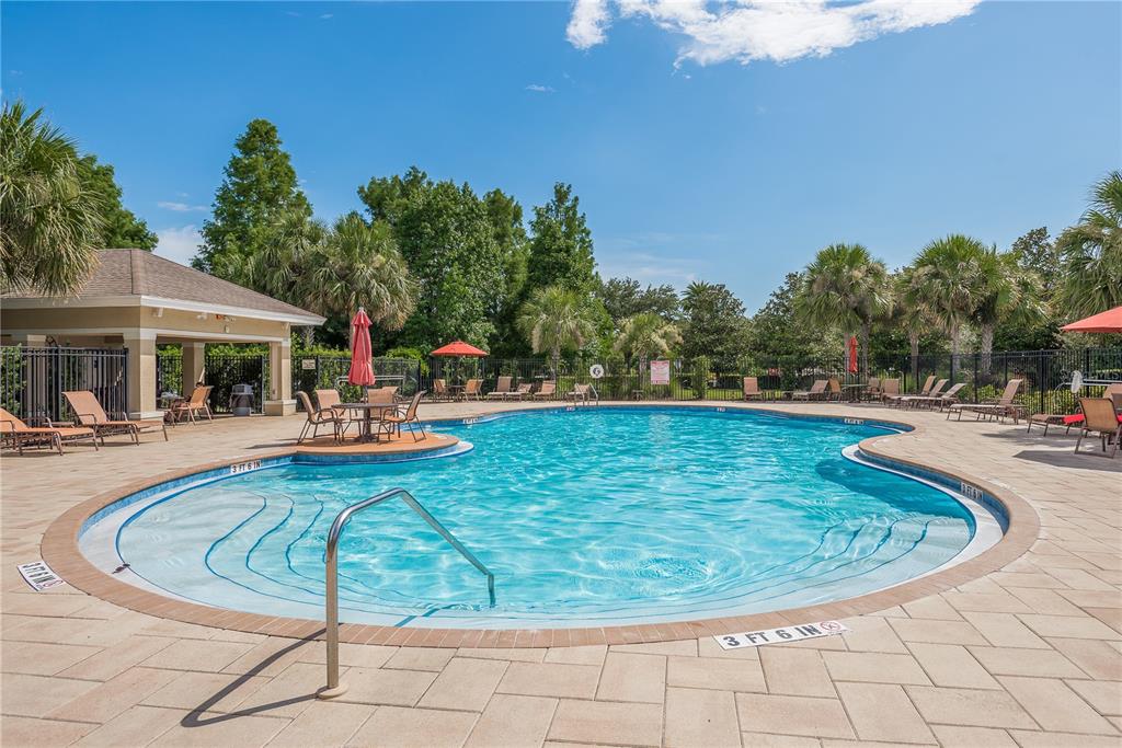 An outdoor swimming pool with a surrounding patio, lounge chairs, and a covered pavilion — 2211 BARRACUDA COURT, HOLIDAY, FL