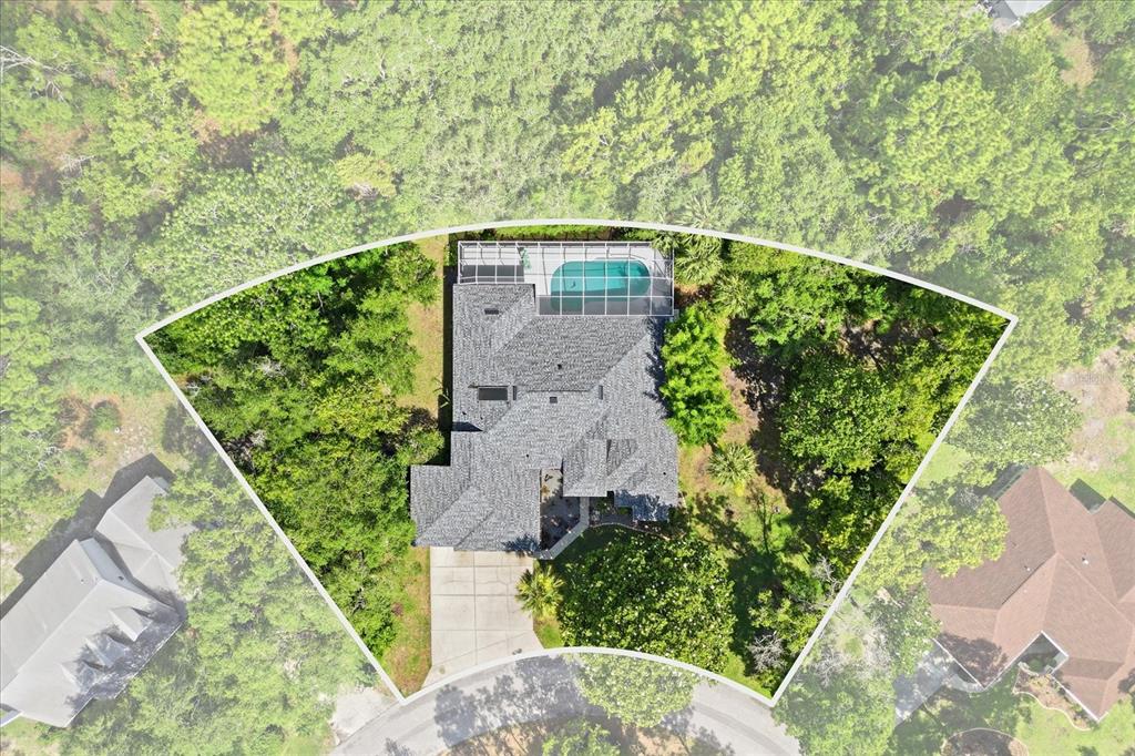 An aerial view shows a house with a screened pool surrounded by dense green trees — 21 FIDDLEWOOD COURT, HOMOSASSA, FL