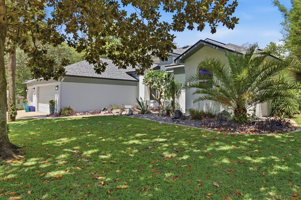 A single-story house with a white exterior, a gray roof, and a landscaped front yard — 21 FIDDLEWOOD COURT, HOMOSASSA, FL
