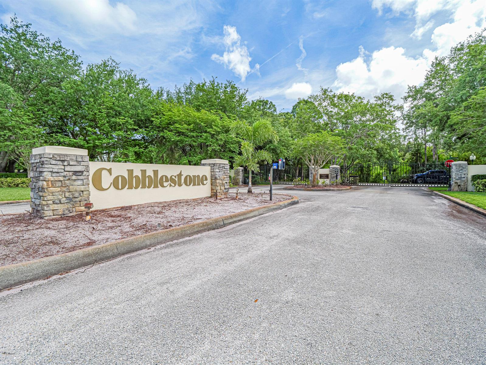 The entrance to the Cobblestone community features a stone monument sign and a gated road — 6489 53rd Circle, Vero Beach FL 32967, VERO BEACH, FL