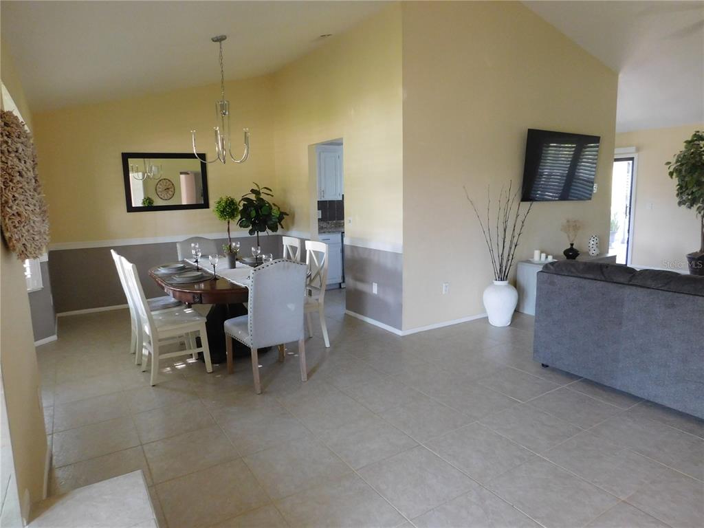 A dining area with a table and chairs sits adjacent to a living room space — 5081 KINGSLEY ROAD, NORTH PORT, FL