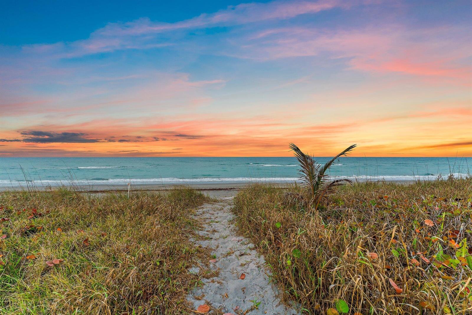 A sandy path leads through beach grass toward the ocean under a colorful sunset sky — 31 N Beach Road, Jupiter Island FL 33455, JUPITER ISLAND, FL