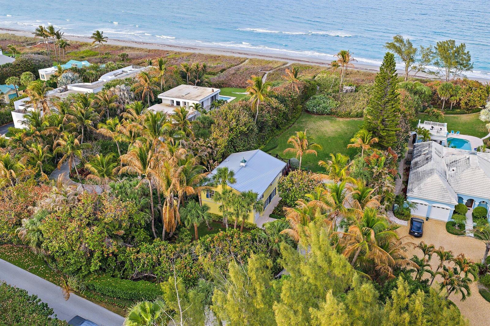 An aerial view shows several houses nestled among lush tropical trees near a sandy beach — 31 N Beach Road, Jupiter Island FL 33455, JUPITER ISLAND, FL