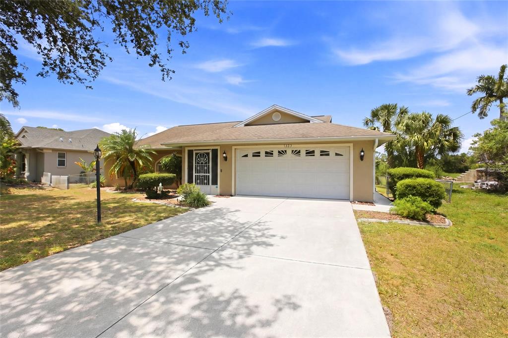 A single-story house with a beige exterior, a two-car garage, and a concrete driveway — 1299 TRIPOLI STREET, NORTH PORT, FL