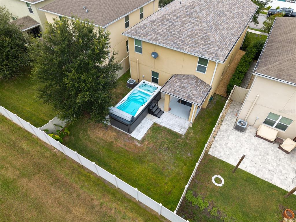 An aerial view shows a backyard with a swim spa, a covered patio, and a fence — 5946 81ST AVENUE N, PINELLAS PARK, FL