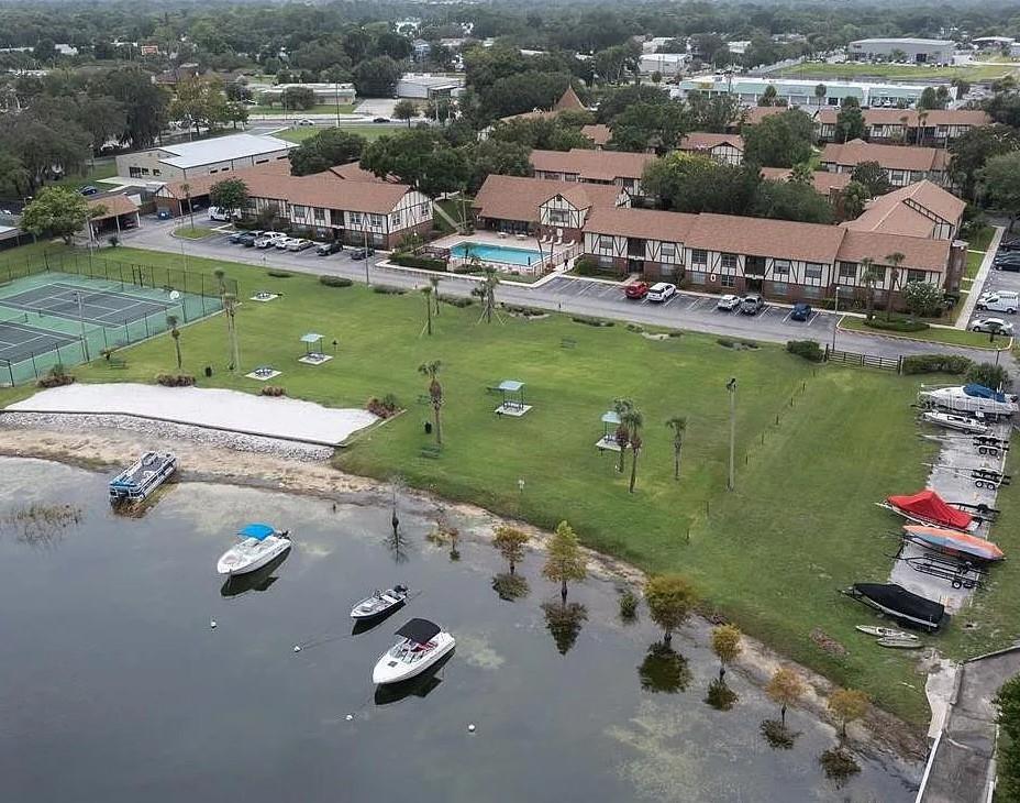 Aerial view of a waterfront apartment complex with a pool, tennis courts, and boat slips — 5425 HANSEL AVENUE UNIT N6, ORLANDO, FL