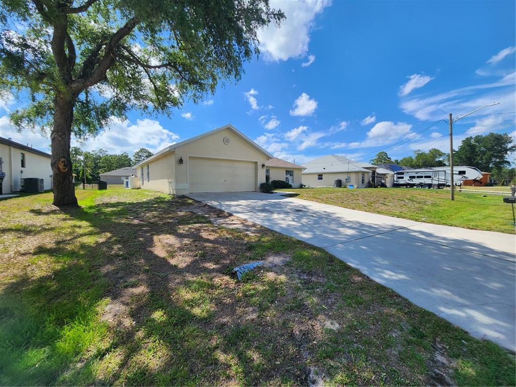 A single-story house with a beige exterior, a two-car garage, and a concrete driveway — 2583 WILBURN TERRACE, NORTH PORT, FL