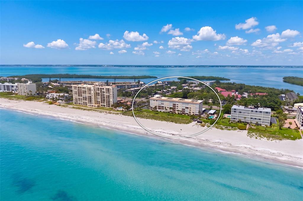 An aerial view of a beachfront condominium building circled on a sandy coastline — 4325 GULF OF MEXICO DRIVE UNIT 402, LONGBOAT KEY, FL