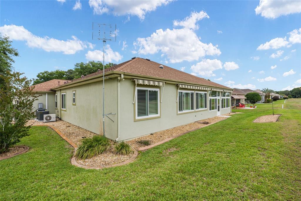 The exterior of a light green house with a brown shingled roof and lawn — 13500 SE 97TH TERRACE ROAD, SUMMERFIELD, FL