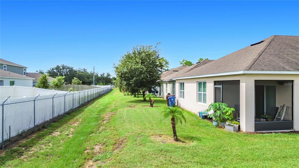 A dining area with a dark wood table and chairs sits adjacent to a living room — 829 SHEEN CIRCLE, HAINES CITY, FL