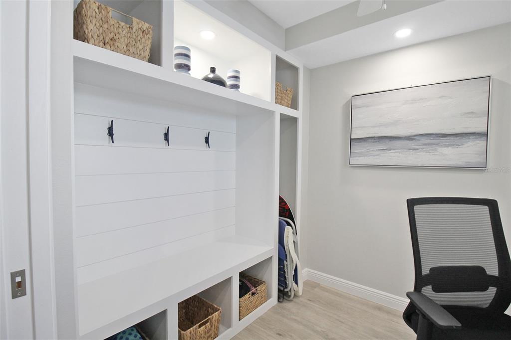 A mudroom area features white built-in cabinetry with cubbies, coat hooks, and a bench seat — 5780 MIDNIGHT PASS ROAD UNIT 609, SARASOTA, FL