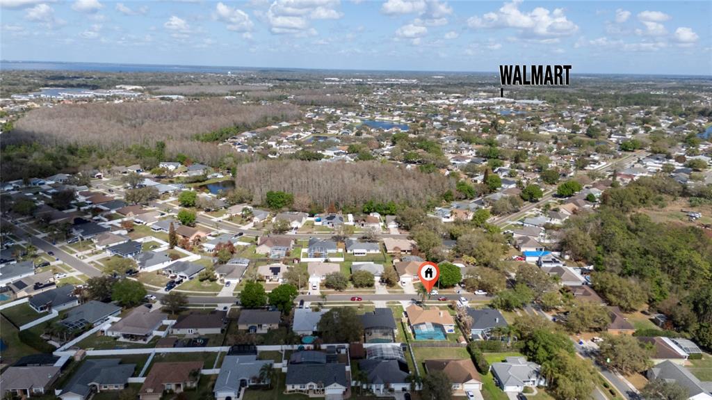 An aerial view shows a residential neighborhood with a highlighted house and a distant Walmart — 3586 YELLOW BIRD COURT, ST CLOUD, FL