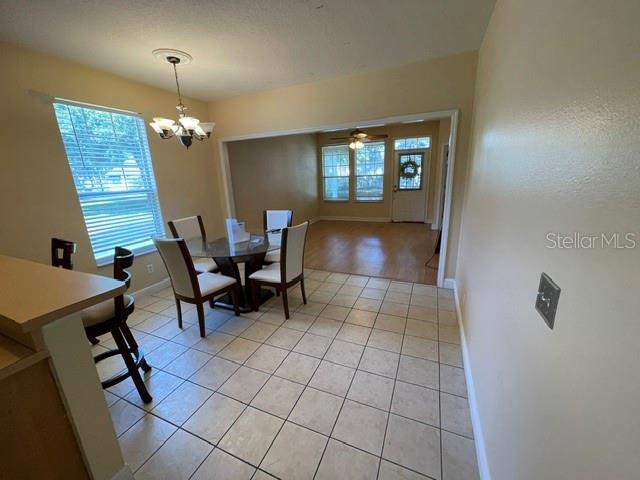 A dining area with tile floors, a chandelier, and a view into an adjacent room — 6344 BIRMINGHAM AVENUE, ZEPHYRHILLS, FL