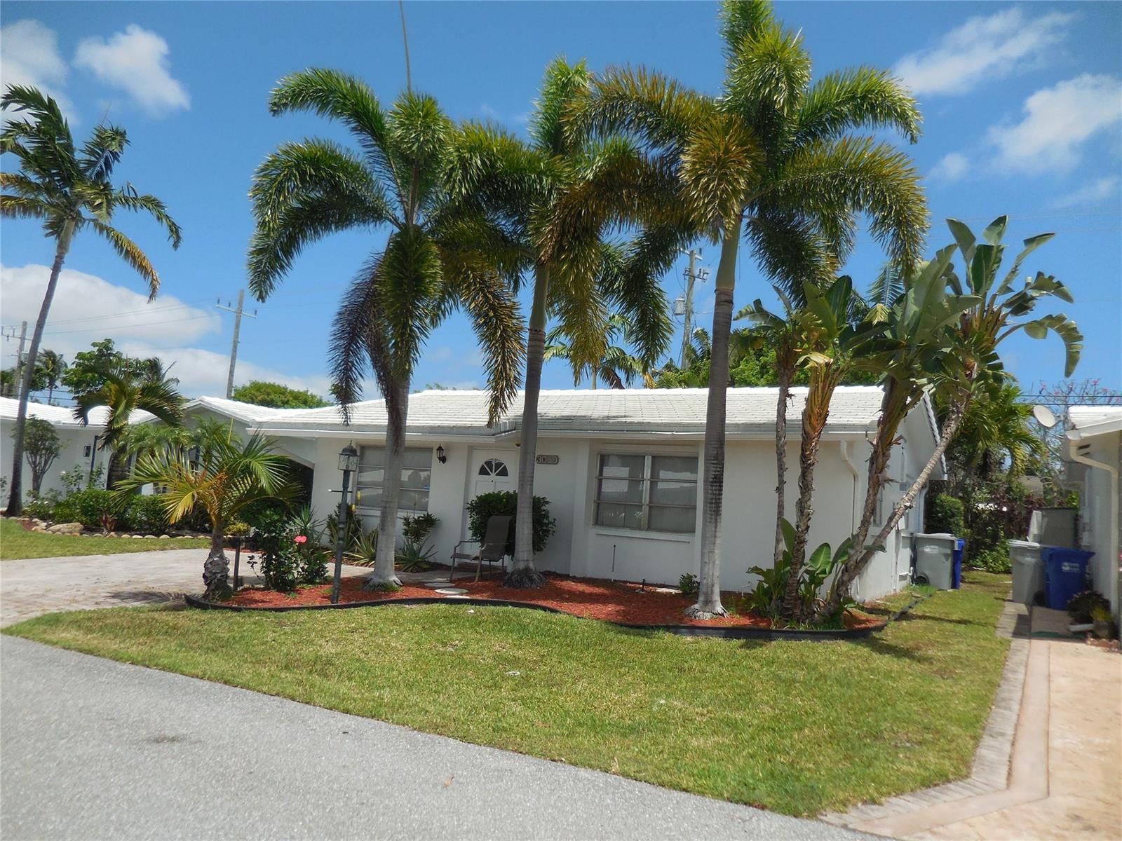 A white single-story house with a palm-filled front yard under a bright blue sky — 3050 NW 1st Avenue, Pompano Beach FL 33064, POMPANO BEACH, FL