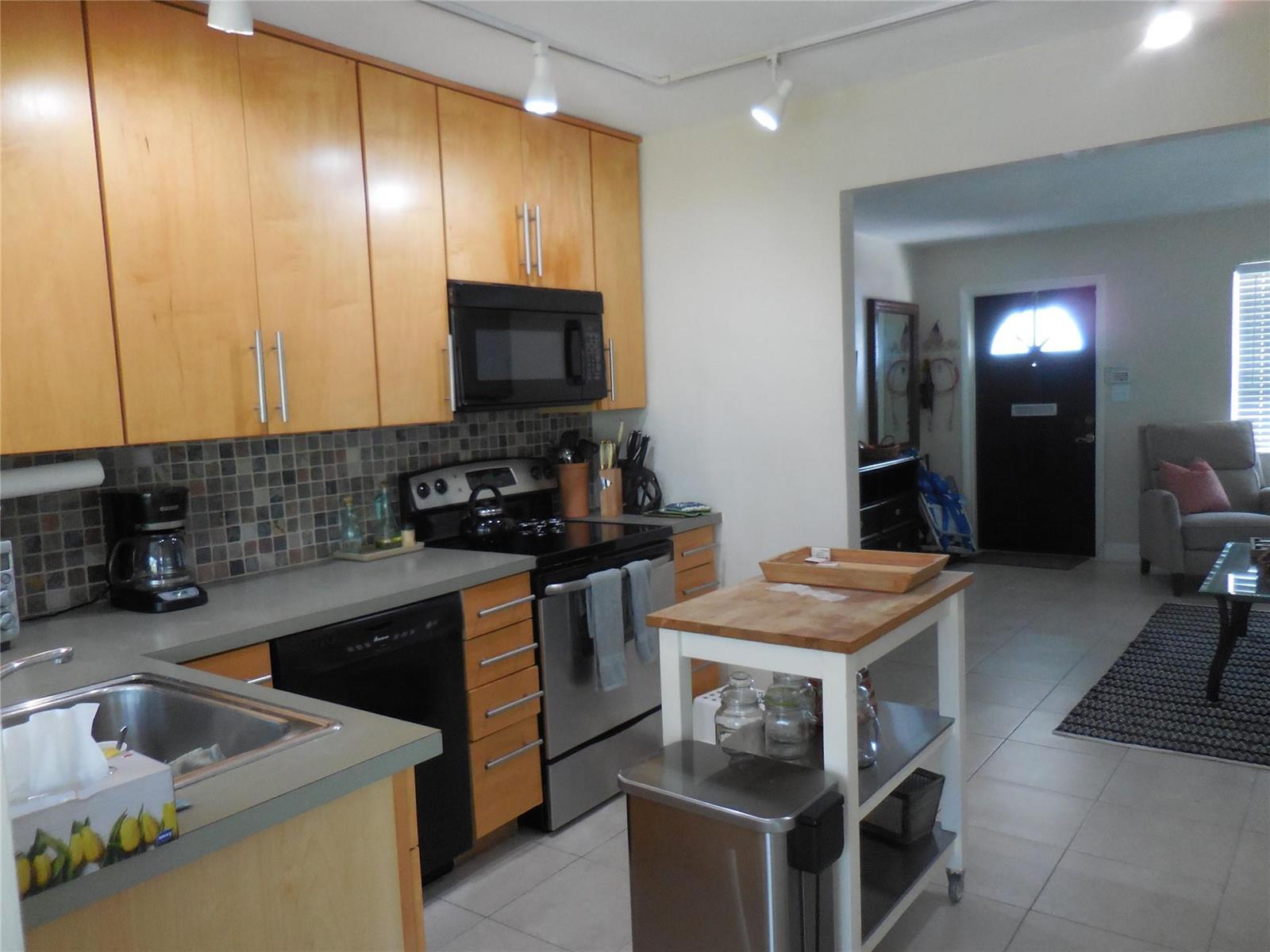 A kitchen with light wood cabinets, stainless steel appliances, and a portable wooden island — 3050 NW 1st Avenue, Pompano Beach FL 33064, POMPANO BEACH, FL