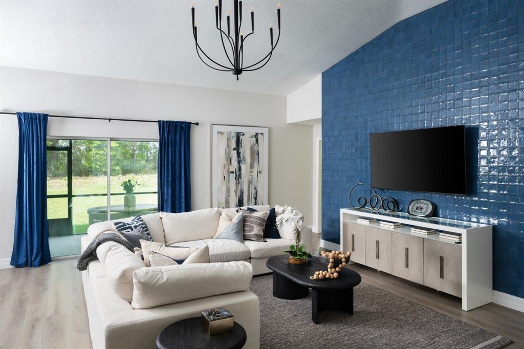 A living room features a blue tiled accent wall, a white sectional, and a chandelier — 6173 SW 97TH STREET, OCALA, FL