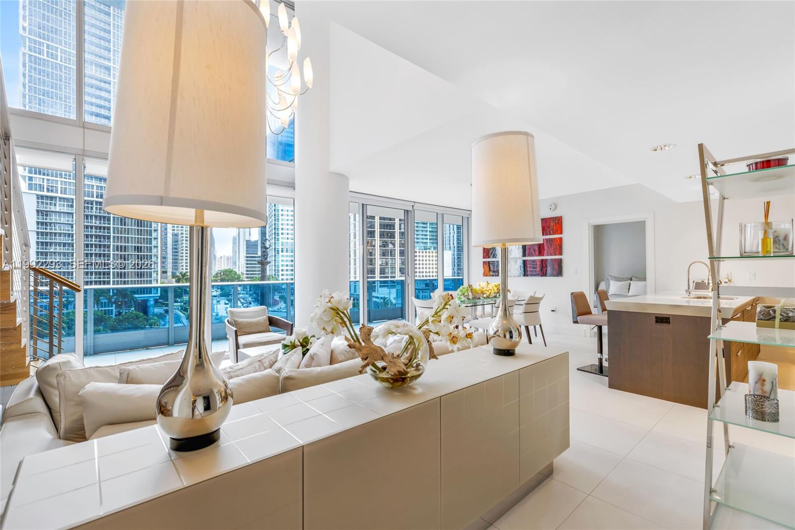 A modern living room features a white console table with two lamps and city views — 200 Biscayne Boulevard Way # 504, Miami FL 33131, MIAMI, FL