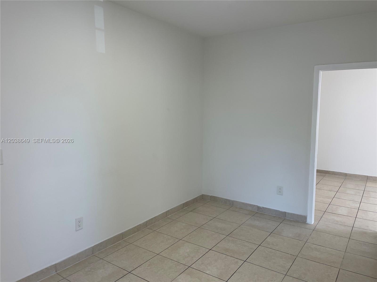 An empty room with white walls, tile flooring, and a doorway leading to another space — 1043 NW 2nd St # 14, Miami FL 33128, MIAMI, FL