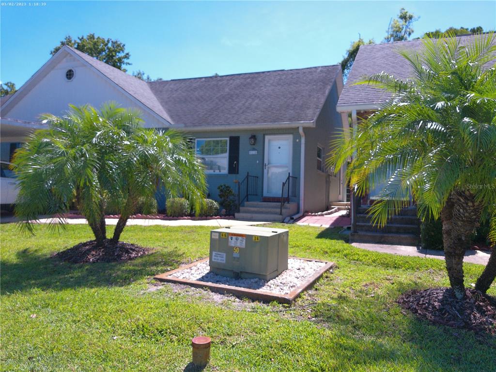 A single-story house with a gray exterior, front steps, and two palm trees in front — 6118 WILDS DRIVE UNIT 0, NEW PORT RICHEY, FL