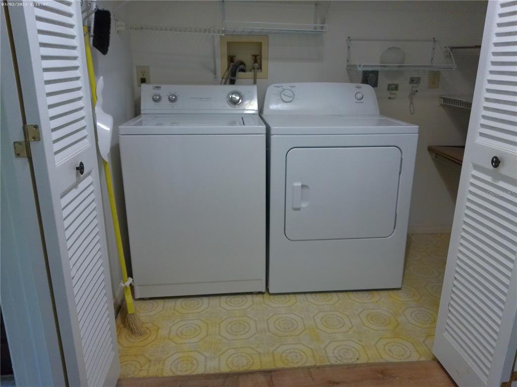 A laundry closet contains a white top-loading washing machine and a white clothes dryer — 6118 WILDS DRIVE UNIT 0, NEW PORT RICHEY, FL