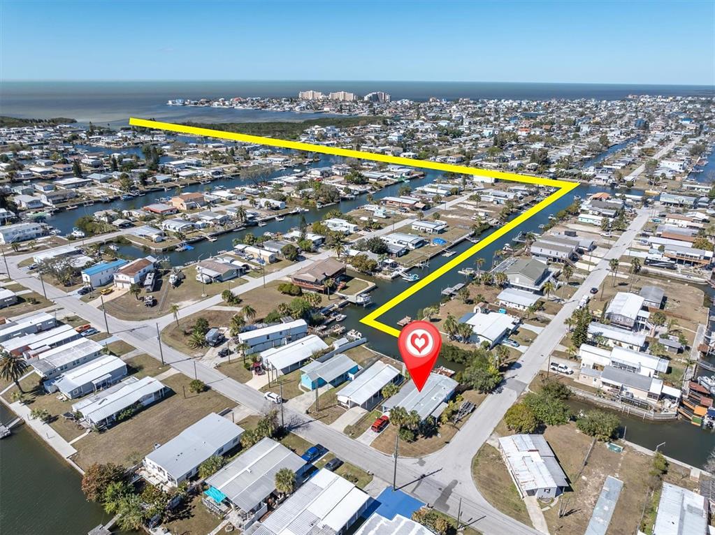 An aerial view shows a residential neighborhood with a highlighted property and canal access — 6629 TOWER DRIVE, HUDSON, FL
